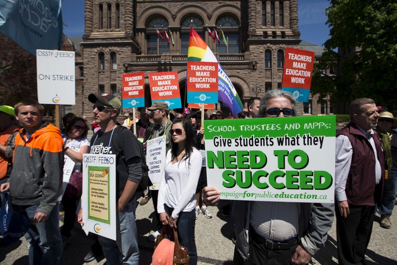 FILE PHOTO: People protest during a rally held by the OSSTF in support of teachers from Ontario's Peel, Durham, and Rainbow school boards who are on strike, at Queen's Park in Toronto