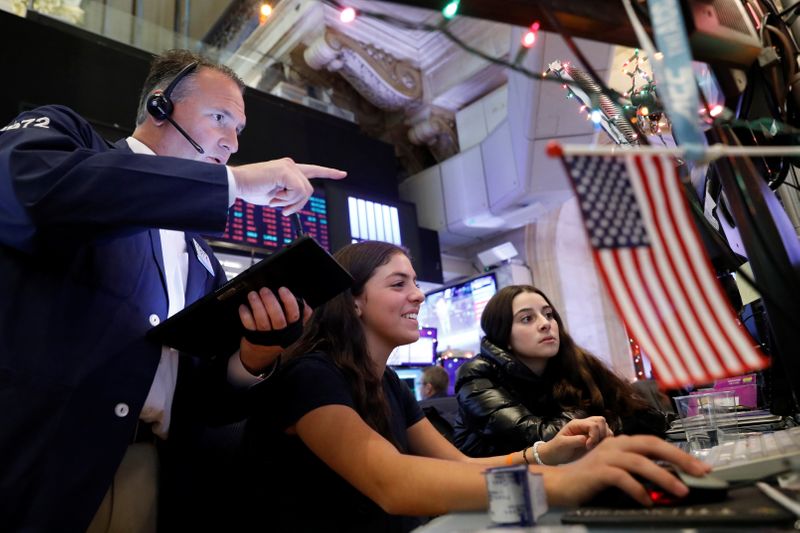 Trader Jonathan Corpina works with children during a traditional bring-your-kids-to-work day on the floor at the NYSE in New York