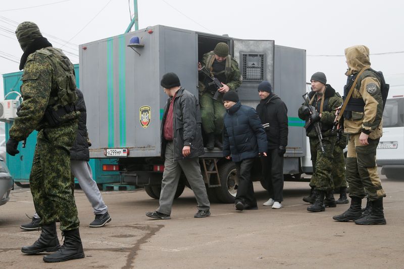Men are escorted during prisoner of war exchange in Donetsk region