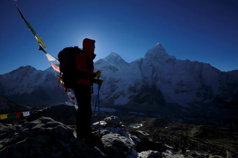 FILE PHOTO: A trekker stands in front of Mount Everest at Kala Patthar in Solukhumbu District
