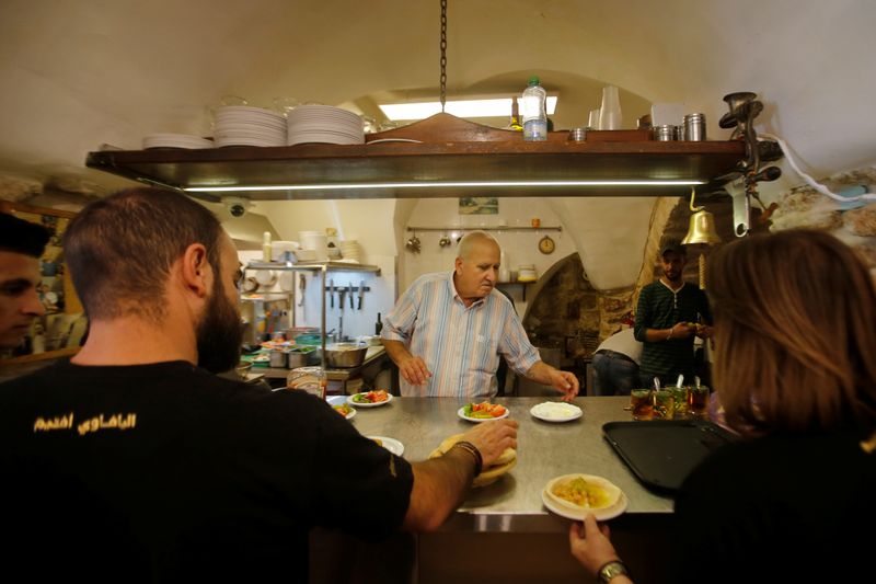 Palestinian man George Salameh, 59, owner of Afteem restaurant, works at his restaurant in Bethlehem, in the Israeli-occupied West Bank