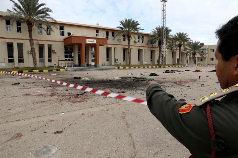 A member of security forcers of the Government of National Accord (GNA) gestures as he inspects the site of an attack on a military academy in Tripoli