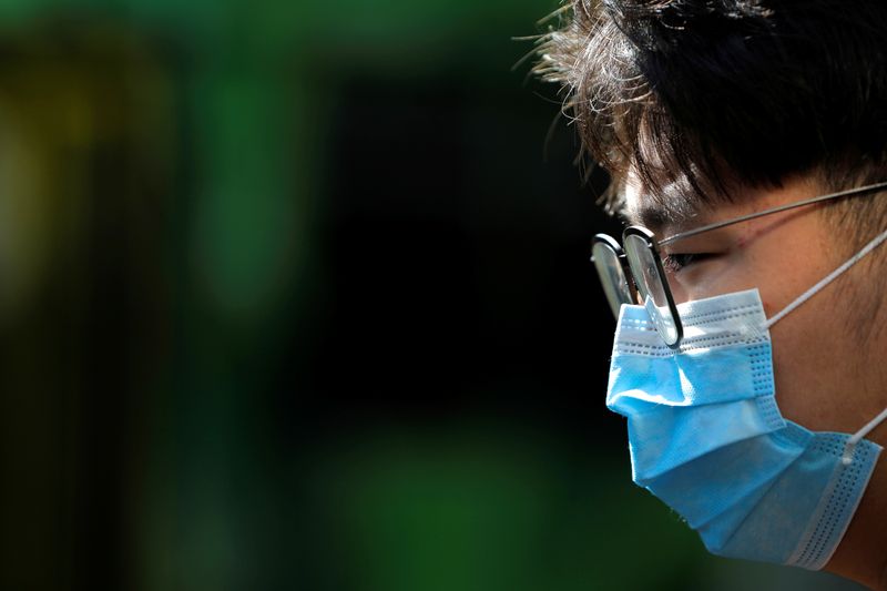 A person wearing a face mask stands on Swanston Street after cases of the coronavirus were confirmed in Melbourne