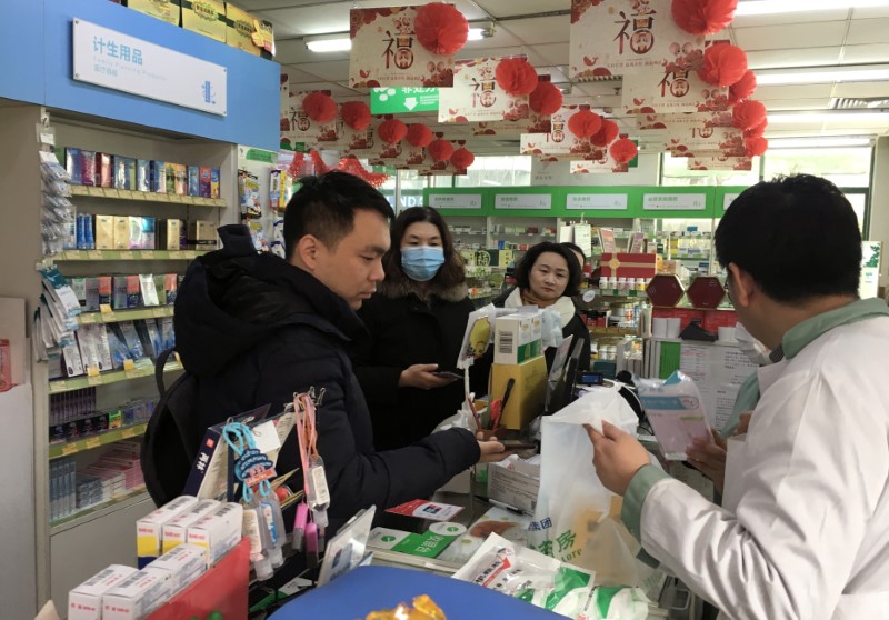 Man pays for masks at a pharmacy in Beijing