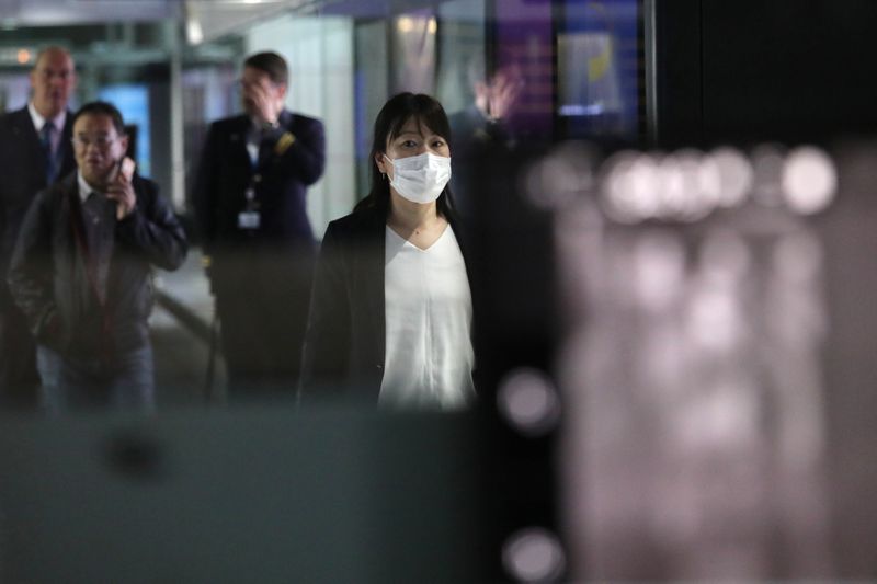 A woman with mask passes by thermal screening point at international arrival terminal of Kuala Lumpur International Airport in Sepang