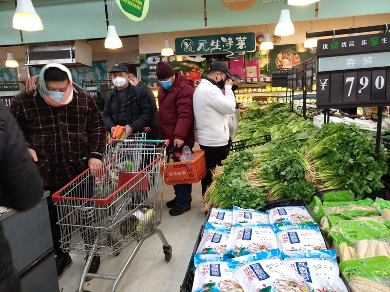 People wearing masks shop at a supermarket on the second day of the Chinese Lunar New Year, following the outbreak of a new coronavirus, in Wuhan, Hubei