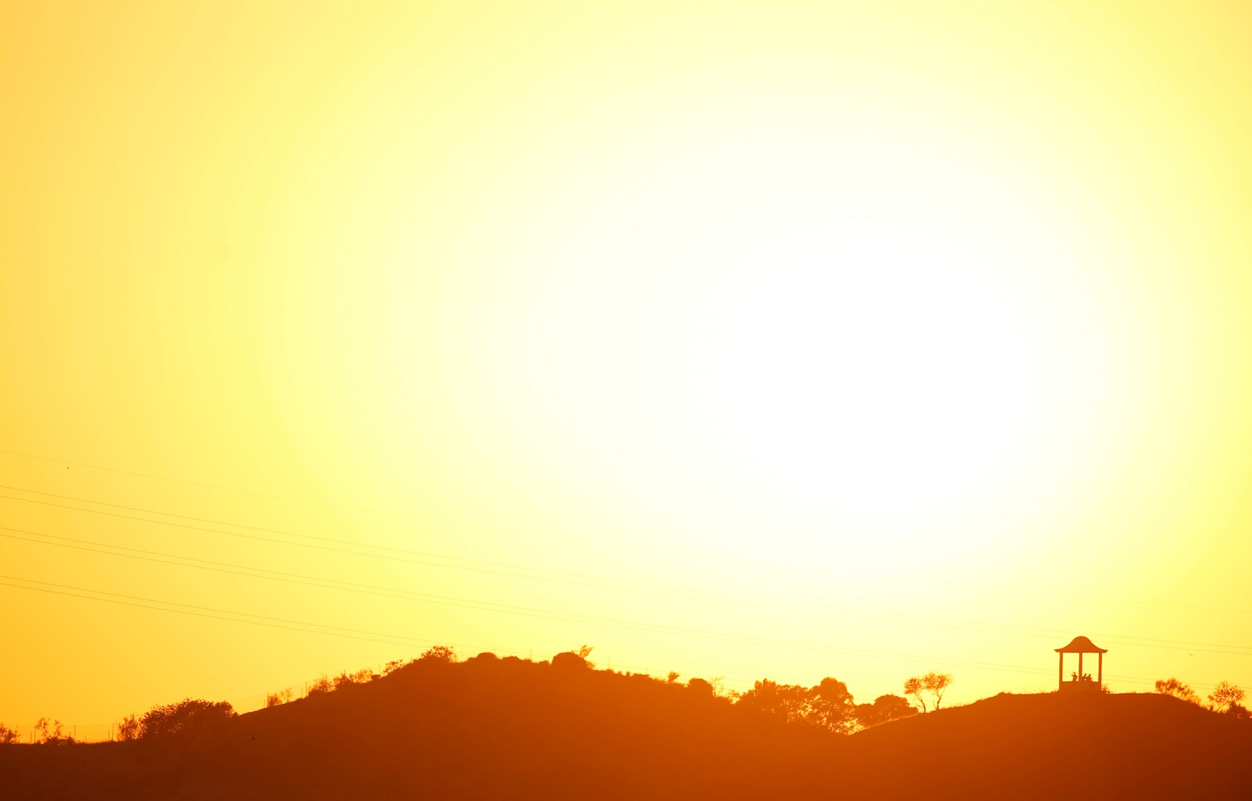 People are silhouetted against the setting sun at 