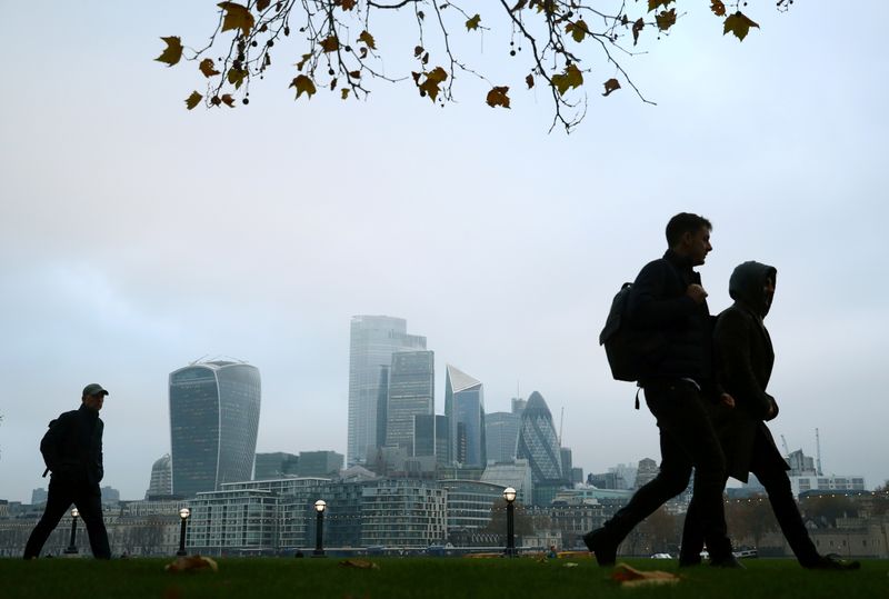 FILE PHOTO: People walk past the financial district in London