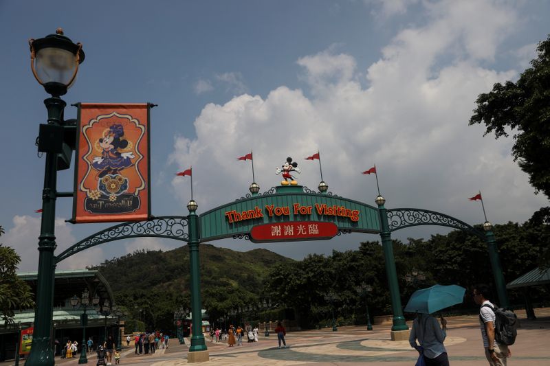 FILE PHOTO: Visitors walk past the entrance to Hong Kong Disneyland in Hong Kong