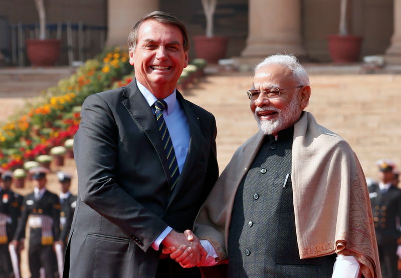 Brazil's President Bolsonaro shakes hands with India's Prime Minister Modi during his ceremonial reception at the forecourt of India's Rashtrapati Bhavan Presidential Palace in New Delhi