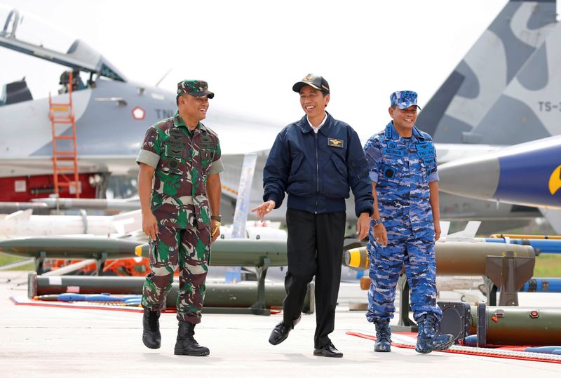 FILE PHOTO: Indonesia's President Joko Widodo walks past fighter jets and weapons during a military exercise on Natuna Island