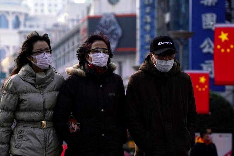 People wearing protective masks walk at the Nanjing Road in Shanghai