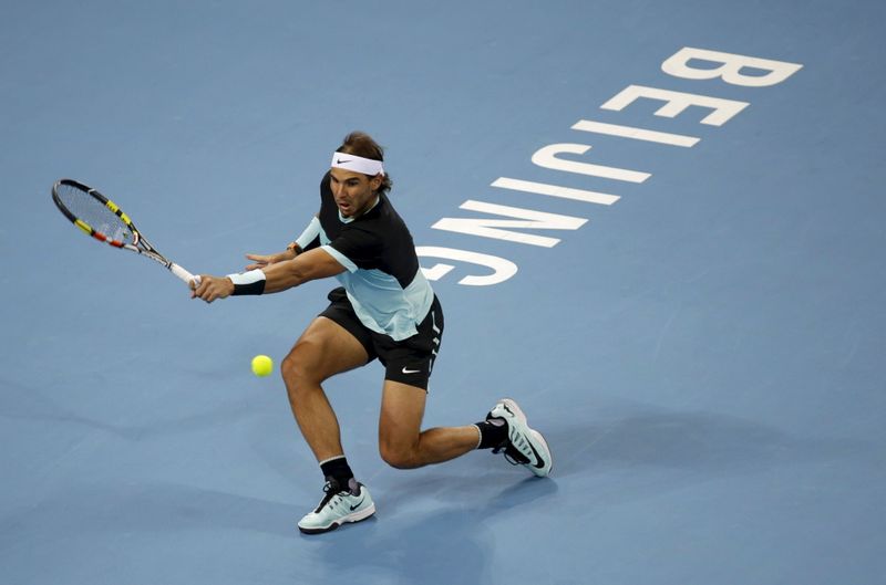 FILE PHOTO:Nadal of Spain hits a return to Djokovic of Serbia during the men's singles final match at the China Open Tennis Tournament in Beijing