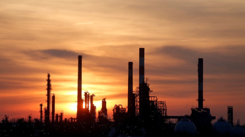 FILE PHOTO: The sun sets behind the chimneys of the Total Grandpuits oil refinery southeast of Paris