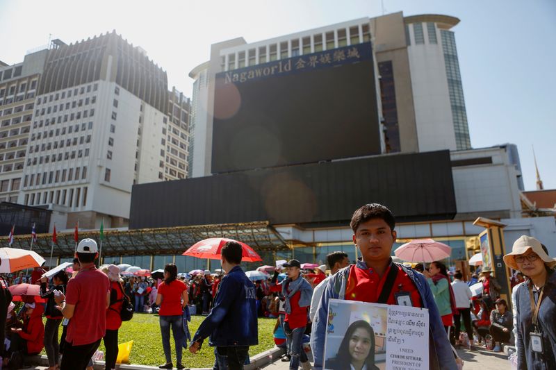 A cambodian worker holds up a placard during a protest for higher pay and better working conditions in front of the NagaWorld hotel and casino complex in Phnom Penh