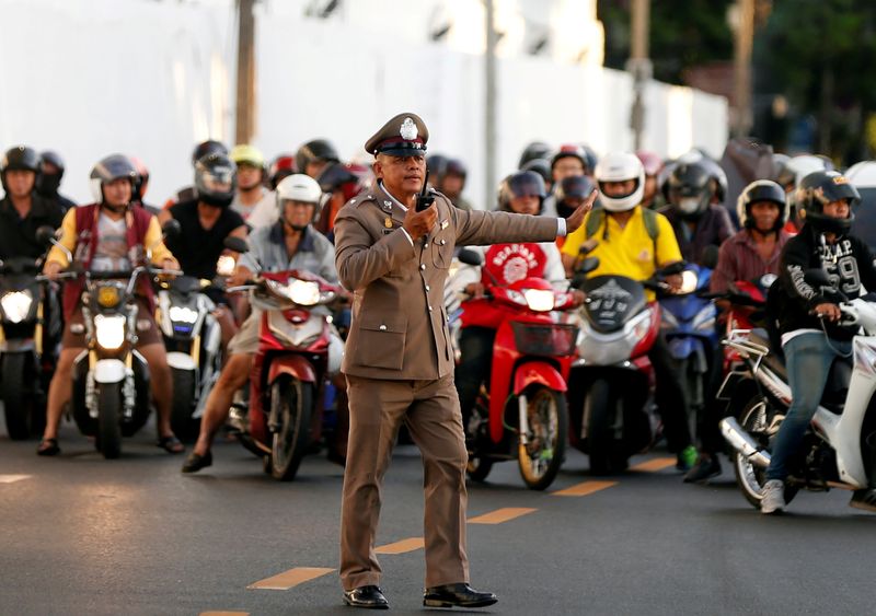 FILE PHOTO: File picture of Thai traffic police stopping vehicles as King Maha Vajiralongkorn's convoy passes