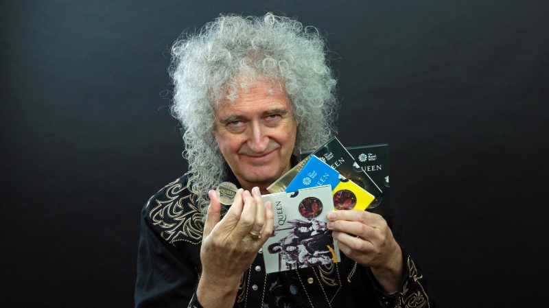 Guitarist Brian May of band Queen poses with a 5-pound coin