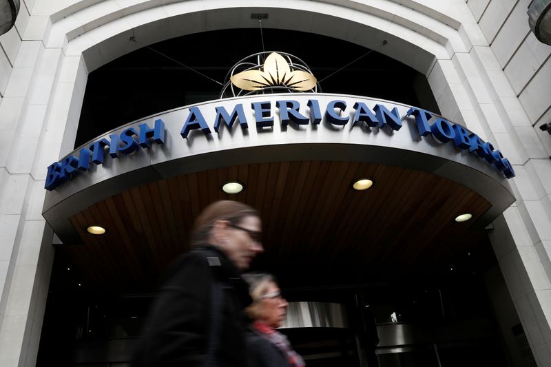 FILE PHOTO: People walk past the British American Tobacco offices in London