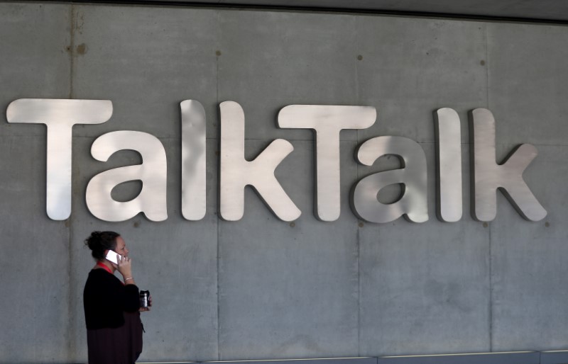 A woman speaks on her phone as she passes a branded logo outside the Talktalk headquarters in London