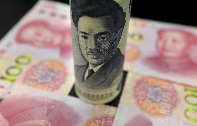 A Japanese 1,000 yen banknote and Chinese 100 yuan banknotes are seen in this picture illustration in Beijing, China