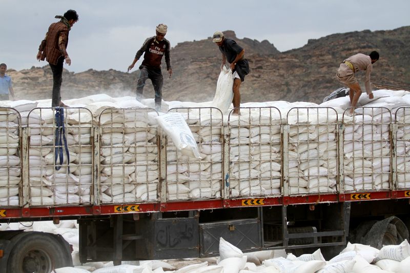 FILE PHOTO: Workers dispose of sacks of World Food Program wheat flour which is reportedly expired or spoiled, on the outskirts of Sanaa