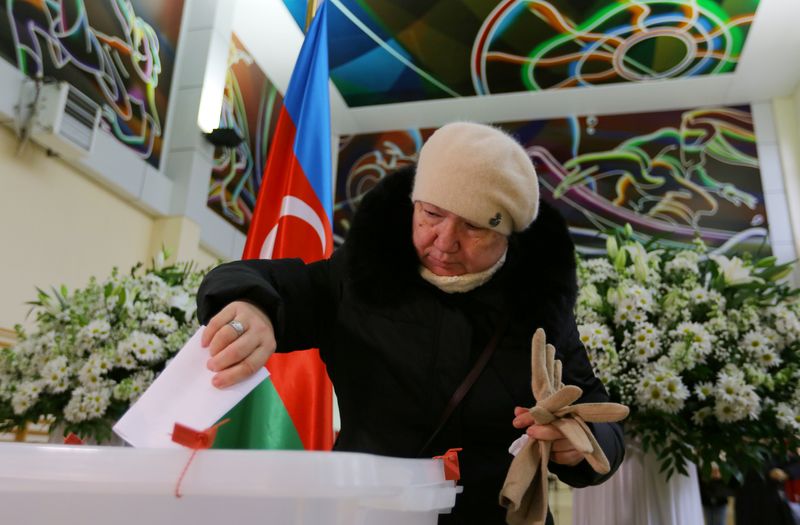 A woman casts her vote at a polling station during a snap parliamentary election in Baku