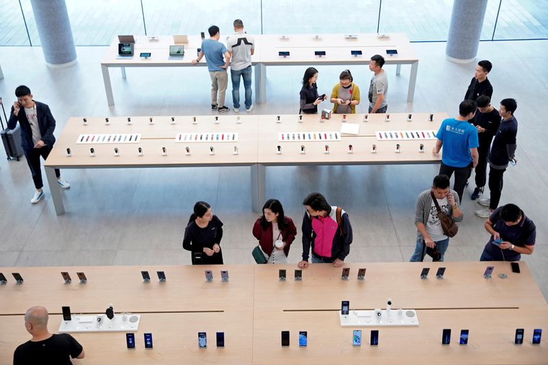 FILE PHOTO: People look at devices in Huawei's first global flagship store in Shenzhen