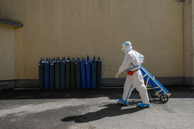 Medical worker in protective suit transports oxygen tank at Wuhan Red Cross Hospital in Wuhan, the epicentre of the novel coronavirus outbreak