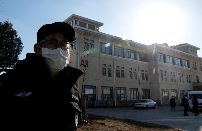 A security guard stands in front of building A3 of the Shanghai Public Clinical Center, where the coronavirus patients are quarantined, in Shanghai
