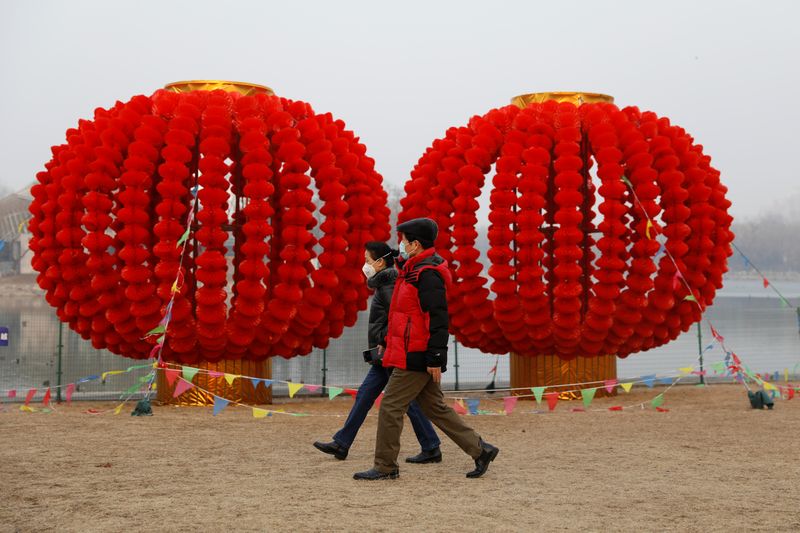 People wearing face masks walk at Longtan Park, as the country is hit by an outbreak of the new coronavirus, in Beijing