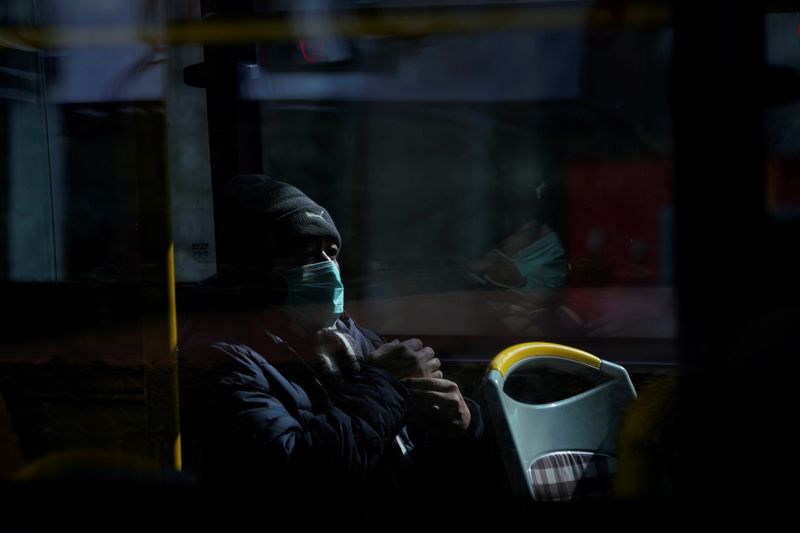 A man wearing a mask is seen on a bus, in downtown Shanghai