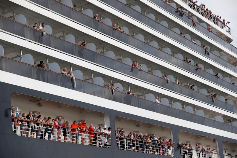 Passengers wave their towels as they are about to leave MS Westerdam, a cruise ship that spent two weeks at sea after being turned away by five countries over fears that someone aboard might have the coronavirus, as it docks in Sihanoukville