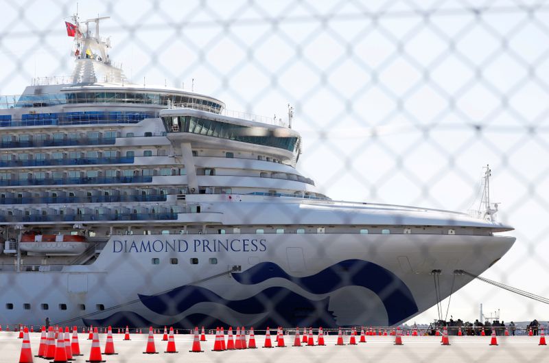FILE PHOTO: The cruise ship Diamond Princess, where dozens of passengers were tested positive for coronavirus, is seen through steel fence at Daikoku Pier Cruise Terminal in Yokohama