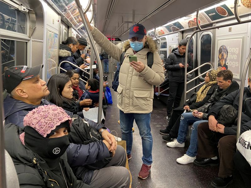 FILE PHOTO: A man with a face mask rides the subway in the Queens borough of New York Cit