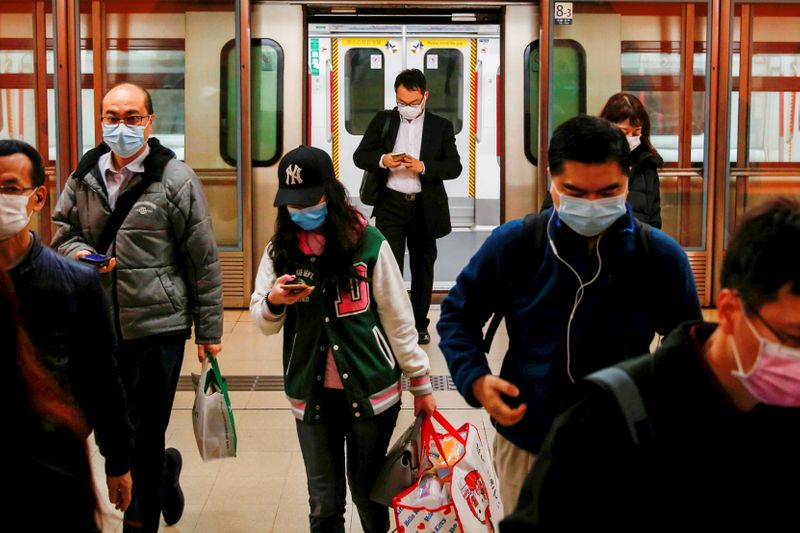 FILE PHOTO: People wear protective masks following the outbreak of a new coronavirus, during their morning commute in a station, in Hong Kong