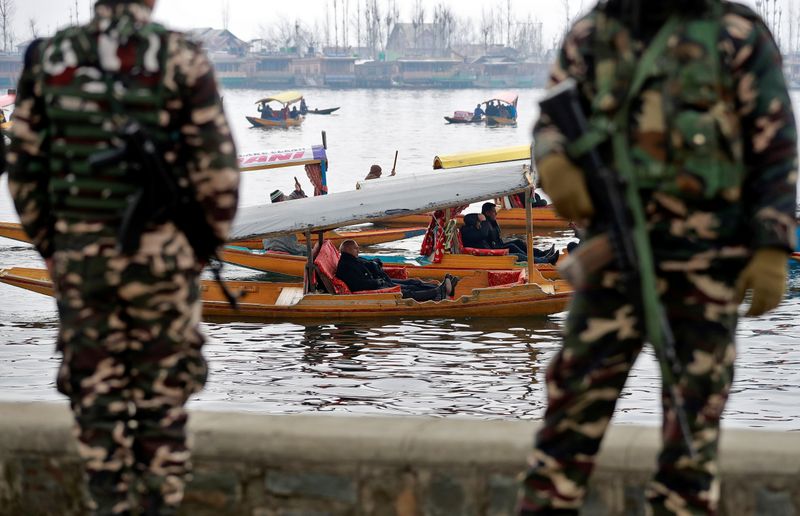 Foreign diplomats are seen in boats as Indian security force personnel stand guard on the banks of Dal Lake in Srinagar