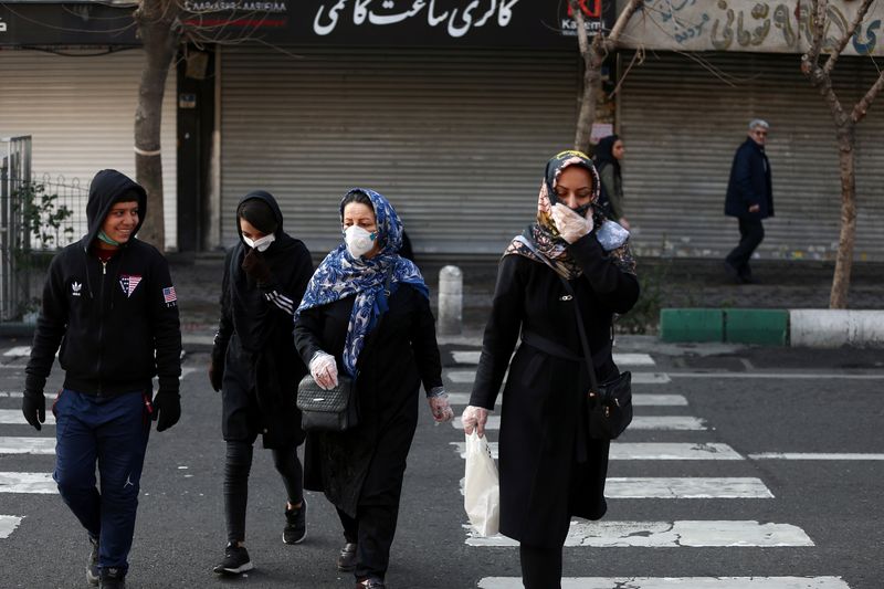 Iranian people wear protective masks to prevent contracting a coronavirus, in Tehran