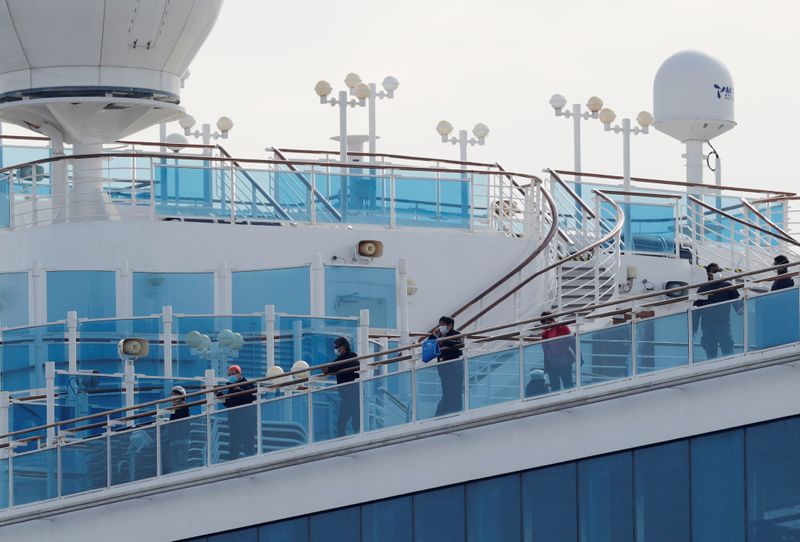 Passengers look out from a deck of the cruise ship Diamond Princess at Daikoku Pier Cruise Terminal in Yokohama, south of Tokyo, Japan