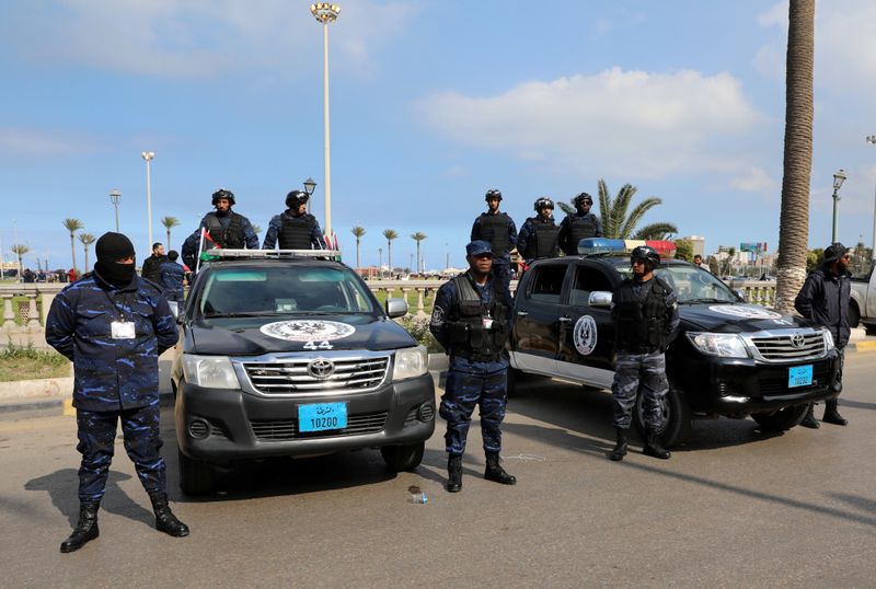 Security forces stand guard during a celebration of the 9th anniversary of the revolution against former Libyan leader Muammar Gaddafi at Martyrs' Square in Tripoli