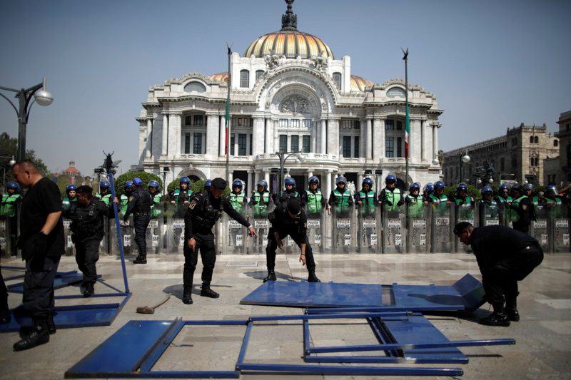 Security forces patrol as demonstrators take part in a protest against gender-based violence outside the Palacio de Bellas Artes in Mexico City