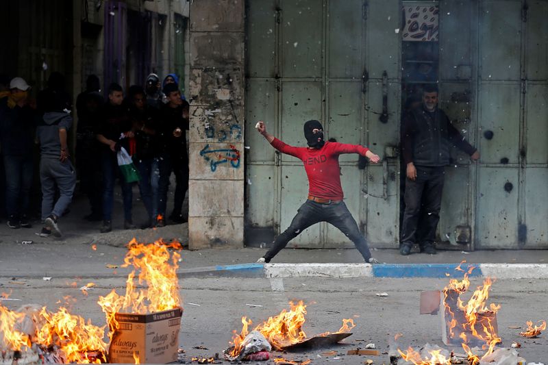 Palestinian hurls stones at Israeli troops during a protest in Hebron in the Israeli-occupied West Bank