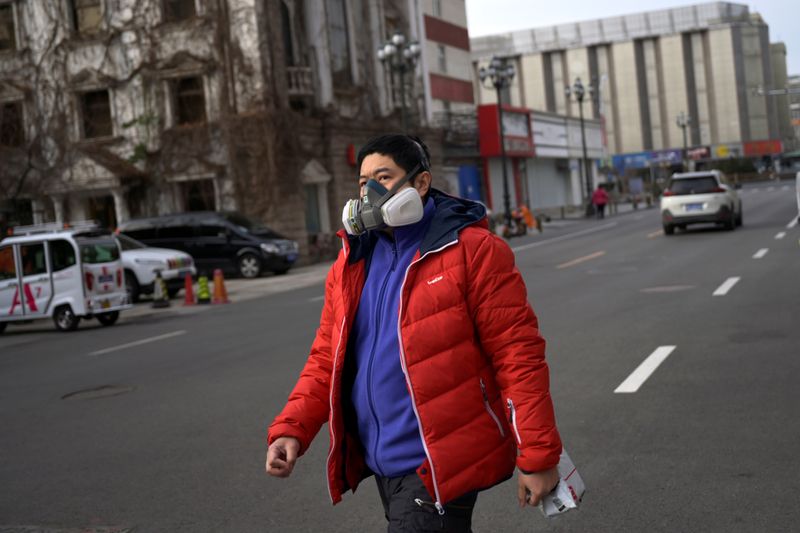 Man wearing a protective face mask walks on a street, as the country is hit by an outbreak of the novel coronavirus, in Beijing
