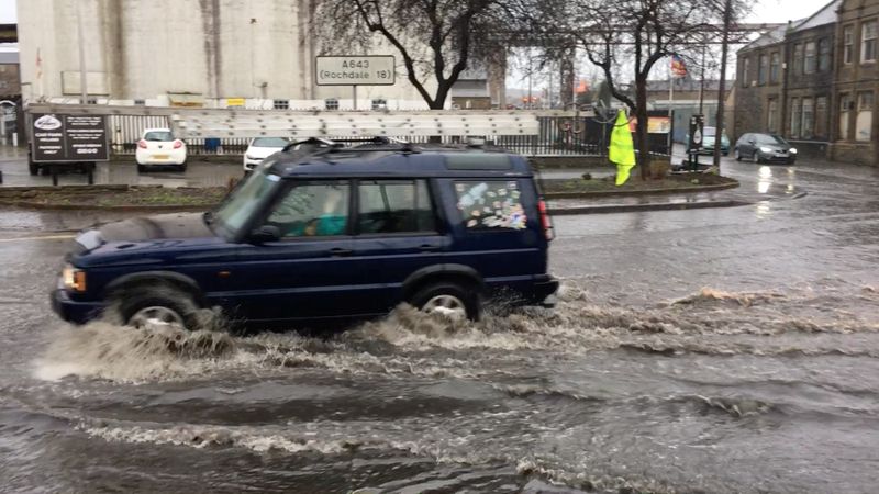 A car drives through a flood water during Storm Ciara in Brighouse