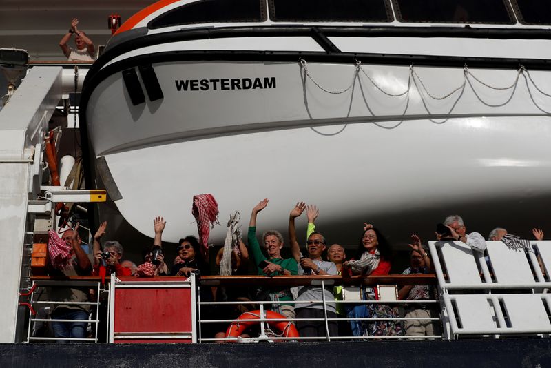 FILE PHOTO: Passengers onboard MS Westerdam, a cruise ship that spent two weeks at sea after being turned away by five countries over fears that someone aboard might have the coronavirus, are seen in Sihanoukville