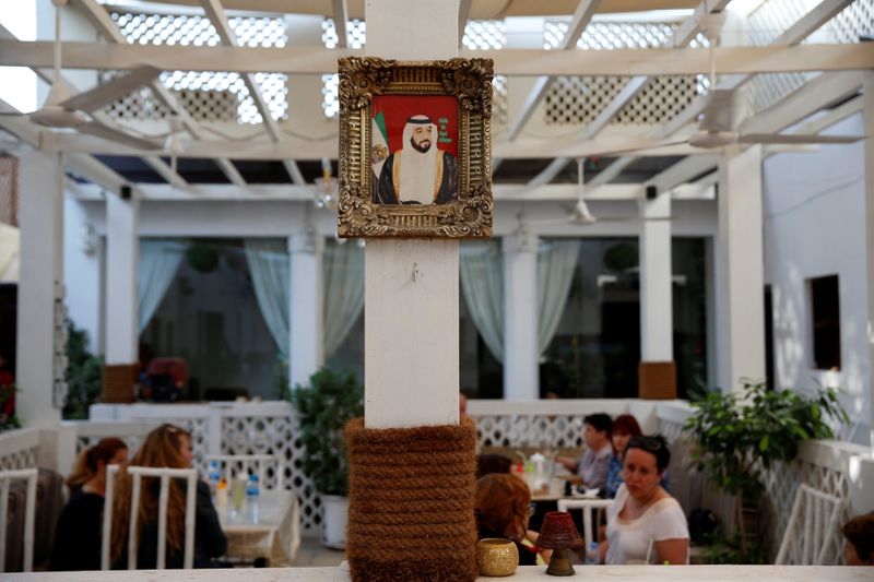 A picture of President of UAE Sheikh Khalifa Al Nahyan is seen as visitors sit inside a cafe in Al Bastakiya, a historic district in Dubai