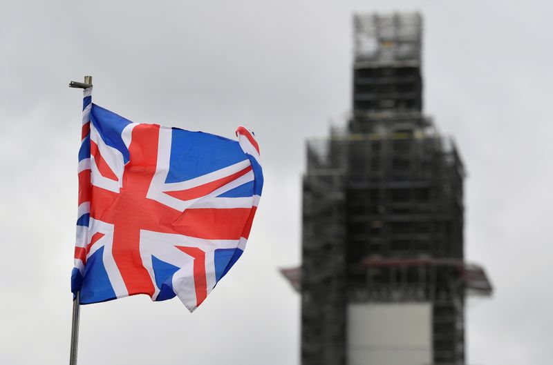 A Union Jack flag flutters as Big Ben clock tower is seen behind at the Houses of Parliament in London