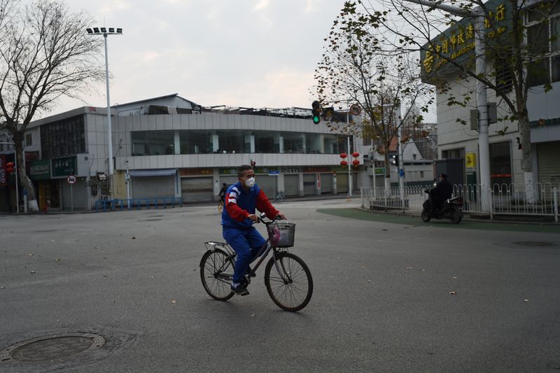 Man wearing a face mask rides a bicycle in Wuhan, the epicentre of the novel coronavirus outbreak,