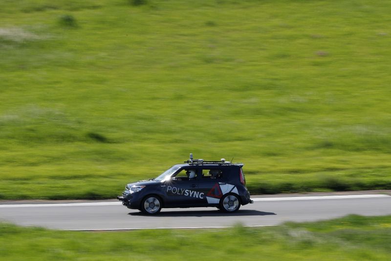 A self-driving car from PolySync drives on the track during a self-racing cars event at Thunderhill Raceway in Willows, California