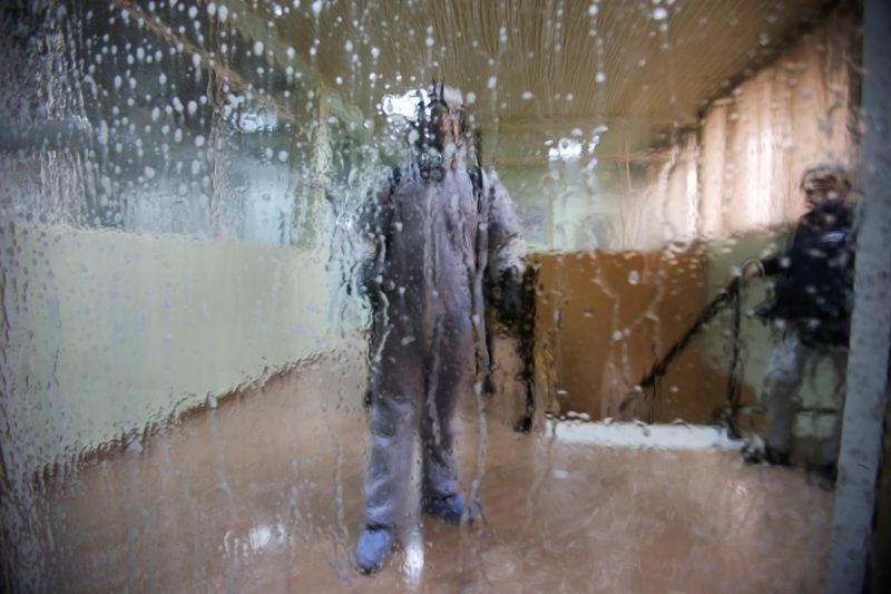 A worker wearing a protective suit disinfects a bus station, following the outbreak of coronavirus disease (COVID-19), in Algiers