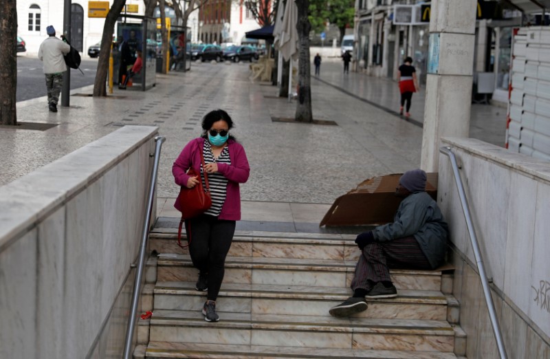 FILE PHOTO: A woman wearing a protective mask as a preventive measure against coronavirus disease (COVID-19) enters the subway at Rossio Square in downtown Lisbon
